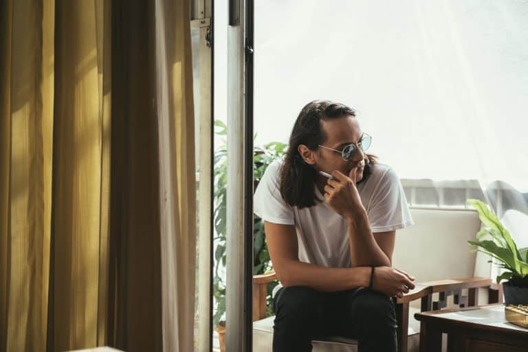 man sitting smoking balcony