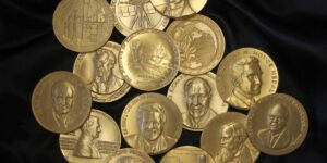 A Group Of Gold Ieee Medals On Black Background.jpg