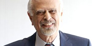 Portrait Of An Older Man Smiling At The Camera Against A White Background.jpg