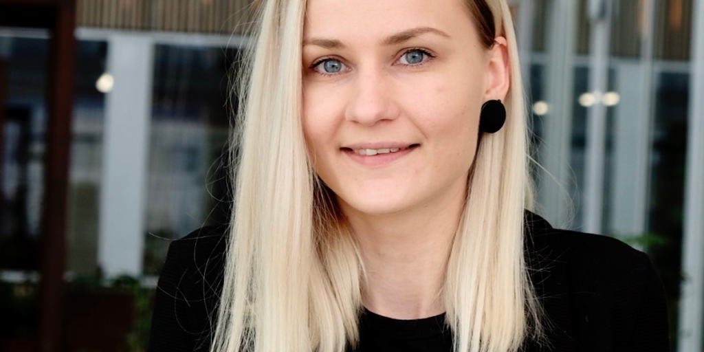 A Woman With Blond Hair And A Black Dress.png