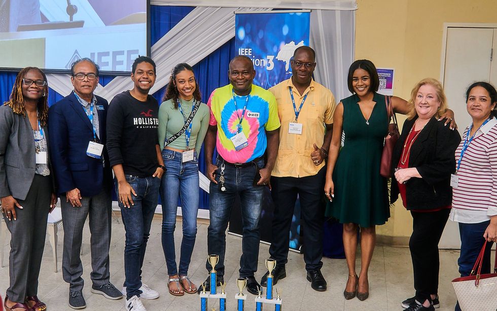 a group of nine people smiling while wearing ieee lanyards